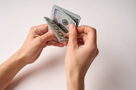 Hands counting us dollar bills. Woman hands holding dollar money on white background, close-up