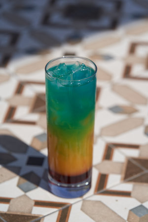 Colorful summer cocktail glass with ice, close-up