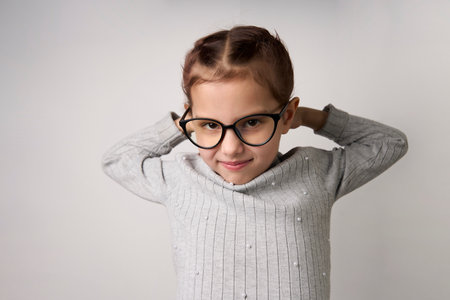 Smiling child girl wearing glasses. Smart girl portrait on white background with copy spaceの写真素材