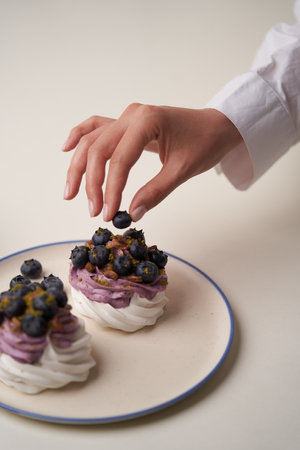 Meringue cupcake with blueberry and pistachio. Dessert Pavlova cake with fresh black currantの写真素材