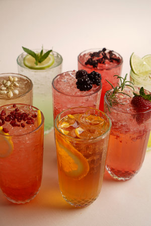 Summer cocktails with pieces of fruit on light background. Iced refreshing drink. Set of various...
