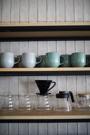 Kitchen shelves with various ceramic plates and glass cups. Kitchenware and utensils. Kitchen interior shelvesの写真素材