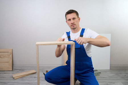 Professional furniture assembly and repair concept. Contractor repairman assembling furniture, indoorsの写真素材