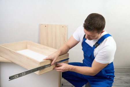 Professional furniture assembly and repair concept. Contractor repairman assembling furniture, indoorsの写真素材