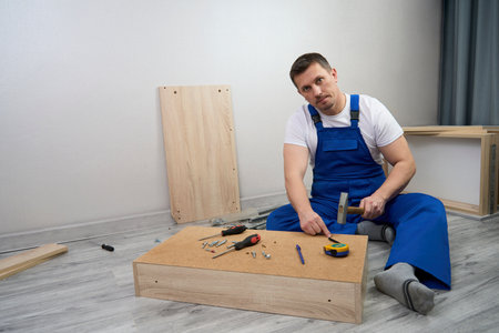 Professional furniture assembly and repair concept. Contractor repairman assembling furniture, indoorsの写真素材