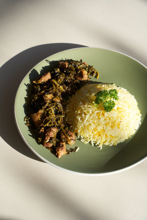 Rice and stew beef and herbs on plate, top view.の写真素材