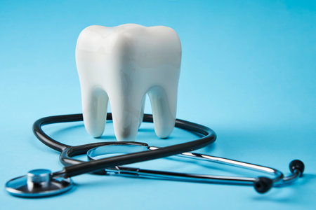 Dental care concept. Tooth and stethoscope on a blue background with copy space, close-up.の写真素材