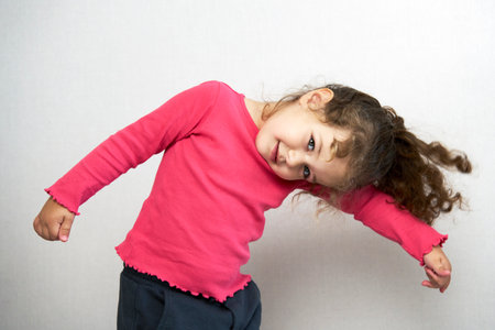 Cute little baby girl posing on a grey background with copy spaceの写真素材