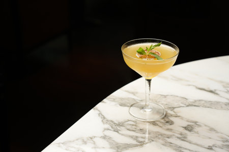 Fresh cocktail glass on a marble bar table. Alcohol cocktail drink, close-up. Modern alcoholic...