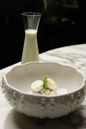 Vegetable salad with eggs and white sauce on a white marble tableの写真素材