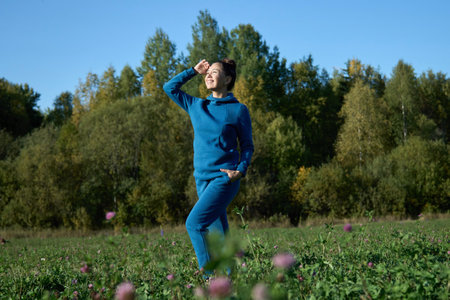 Happy woman enjoying freedom outdoors. Young woman walking in field in fieldの写真素材