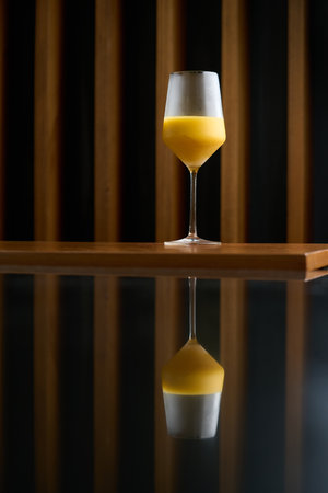 Classic cocktail glass with fresh grapefruit on wooden table in night club restaurant. Alcohol cocktail drink, close-up. Modern alcoholic beverageの写真素材