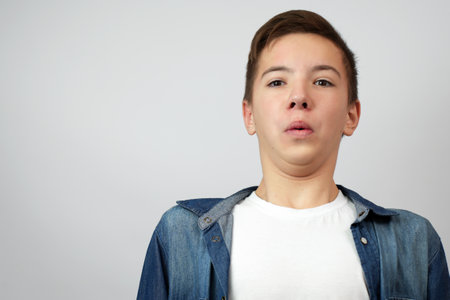 Shocked surprised astonished boy looking at camera, white background with copy spaceの写真素材