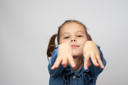 Cute little girl showing her hands to camera, close-up, white backgroundの写真素材