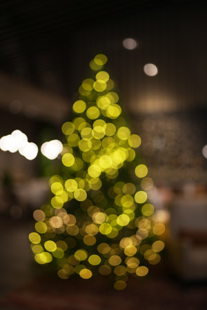 Blurred christmas tree decorated with christmas lights and baubles, indoor, verticalの写真素材