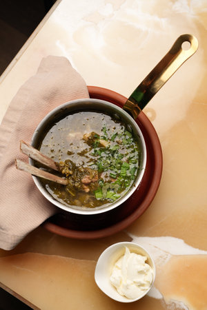 Lamb soup with spinach herbs and sorrel leaves in saucepan, close-upの写真素材