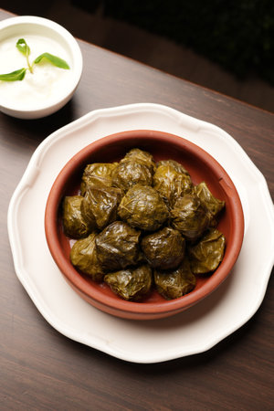 Delicious dolma, stuffed grape leaves with lamb meat. Turkish Yaprak sarma with sauce