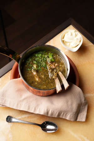 Lamb soup with spinach herbs and sorrel leaves in saucepan, close-upの写真素材