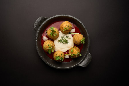 Fried falafel chicken balls with tomato sauce. Battered chicken balls served with tomato sauce in frying panの写真素材