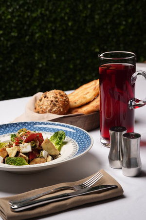 Vegetarian eggplant salad with baked aubergine, cherry tomatoes and cheese. Vegetable salad with cherry juice and bread on a tableの写真素材