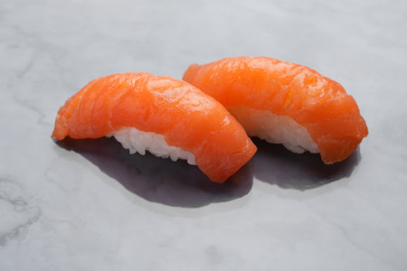 Japanese Nigiri sushi with raw salmon, close-up. Sashimi with rice and salmon fillet on the background of a marble table. Japanese food.の写真素材