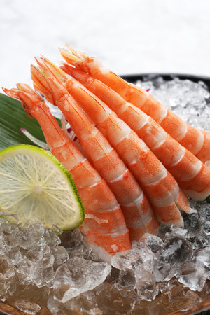 Shrimp Sashimi in Japanese plate. Fresh Sashimi shrimps with ice and lemon, close-up. Asian food menu on marble backgroundの写真素材