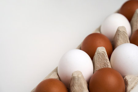 Brown and white eggs in carton on white with clipping path. Chicken egg on white background,...