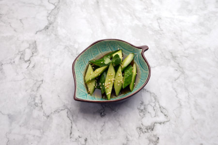 Tataki Kyuri Cucumbers in a bowl. Japanese Smashed Cucumbers on a marble table background with copy spaceの写真素材