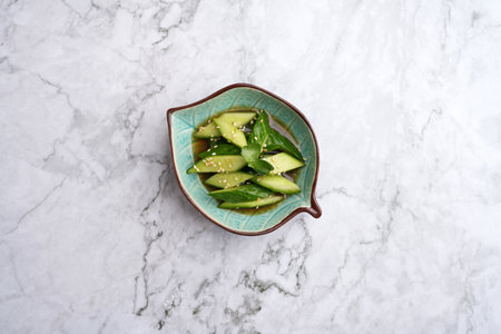 Tataki Kyuri Cucumbers in a bowl. Japanese Smashed Cucumbers on a marble table background with copy spaceの写真素材