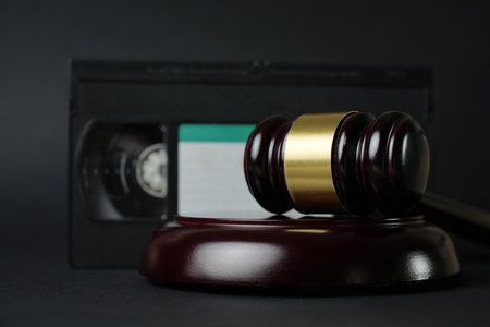 Video copyright law concept. VHS cassette tape and judge gavel background with copy-space. Film piracy and owners rightsの写真素材