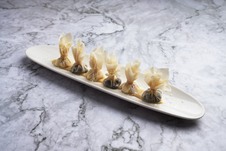 A wonton Chinese dumpling served on a white plate , marble background with copy space