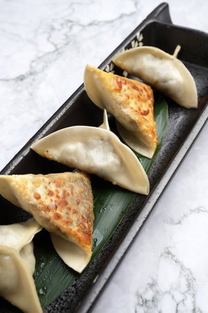 Traditional japanese gyoza dumplings with meat and mushrooms on black plate. Japanese fried gyoza...
