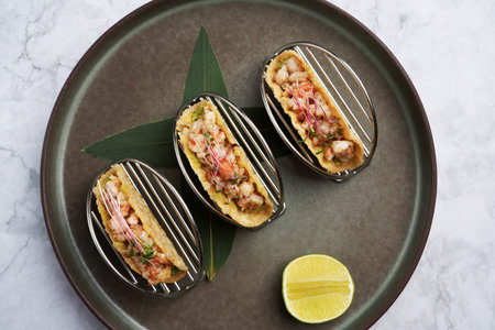 Shrimps tacos with salsa, vegetables and avocado. Traditional Mexican food menu