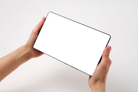 Close up of woman hand holding modern digital tablet mockup. New modern black frameless tablet...