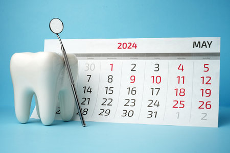 Dentist appointment calendar on a blue background with copy space. Reminder calendar for visiting dental clinic. Dentistry check up dateの写真素材