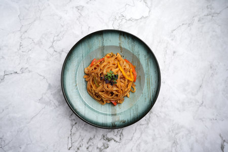 Bowl of Noodles with Vegetables on a marble table background with copy space