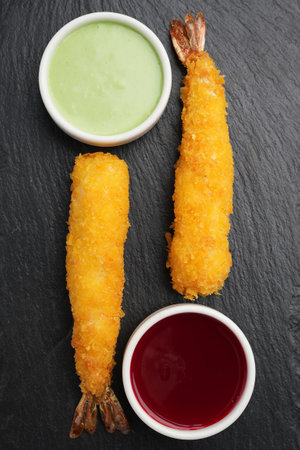 Fried shrimps tempura with chili sauces on a black stone board, traditional japanese cuisine menuの写真素材