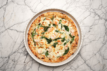 Italian shrimp pizza. Pizza with shrimps, herbs and cheese on a white plateの写真素材