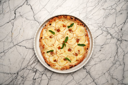 Italian fruit pizza. Pizza with pears, herbs and cheese on a white plateの写真素材