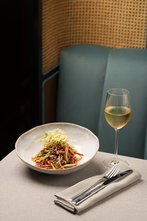 Sliced meat and vegetables salad in a white bowlの写真素材