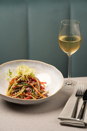 Veal salad with vegetables and teriyaki. Sliced meat and vegetables salad in a white bowlの写真素材