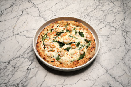 Italian shrimp pizza. Pizza with shrimps, herbs and cheese on a white plateの写真素材