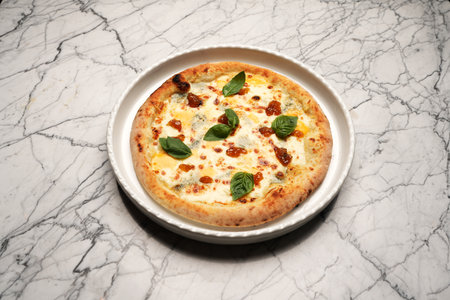 Italian formaggi pizza. Pizza with herbs and cheese on a white plateの写真素材