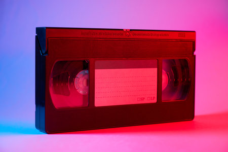 Videocassette on colorful background with blue and pink lightの写真素材