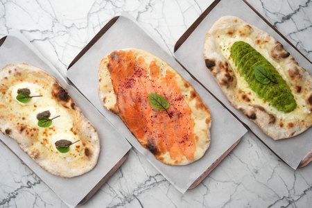 Set of three Pizzas with smoked salmon, avocado, truffle, cheese and pita bread, top viewの写真素材