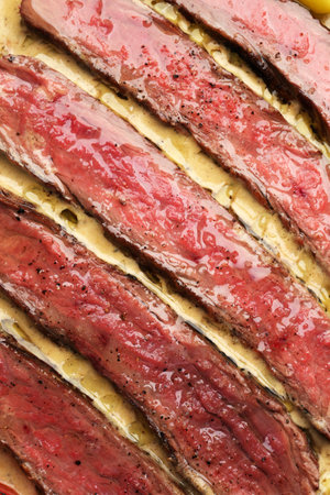 Sliced beef steak with sauce, tomato and chilli pepperの写真素材