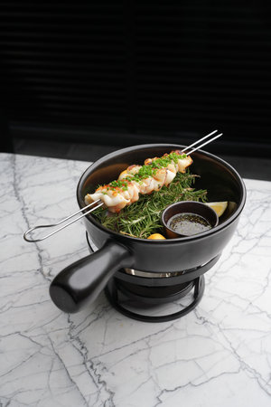 Grilled squid skewers with herbs and sauceの写真素材