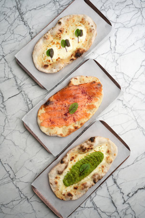 Set of three Pizzas with smoked salmon, avocado, truffle, cheese and bread, top view