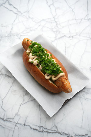 Hot dog with chicken sausage, green onion and sauceの写真素材