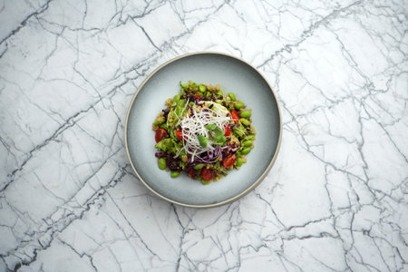 Quinoa salad with beans and vegetables bowl, on a marble table background with copy space, close-upの写真素材